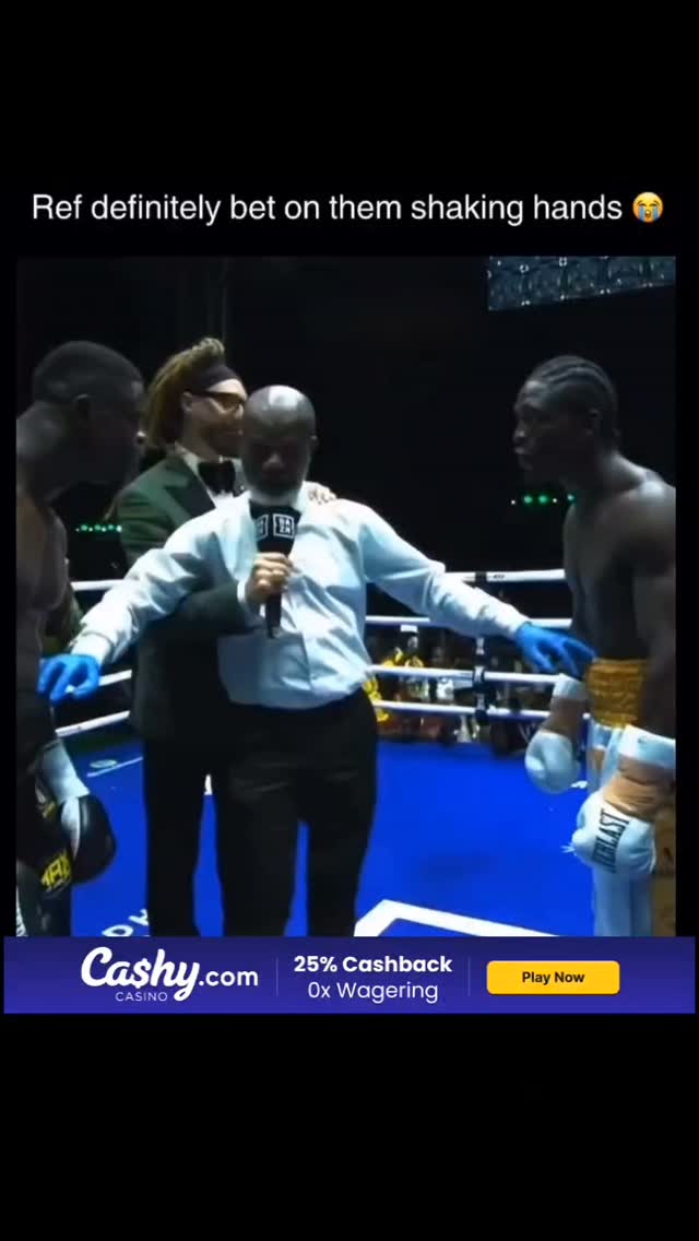 Ref stands between two boxers in th...