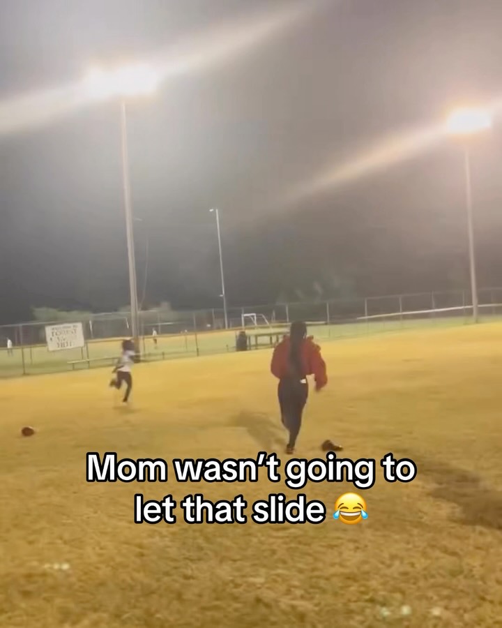 Mom chases child on a sports field