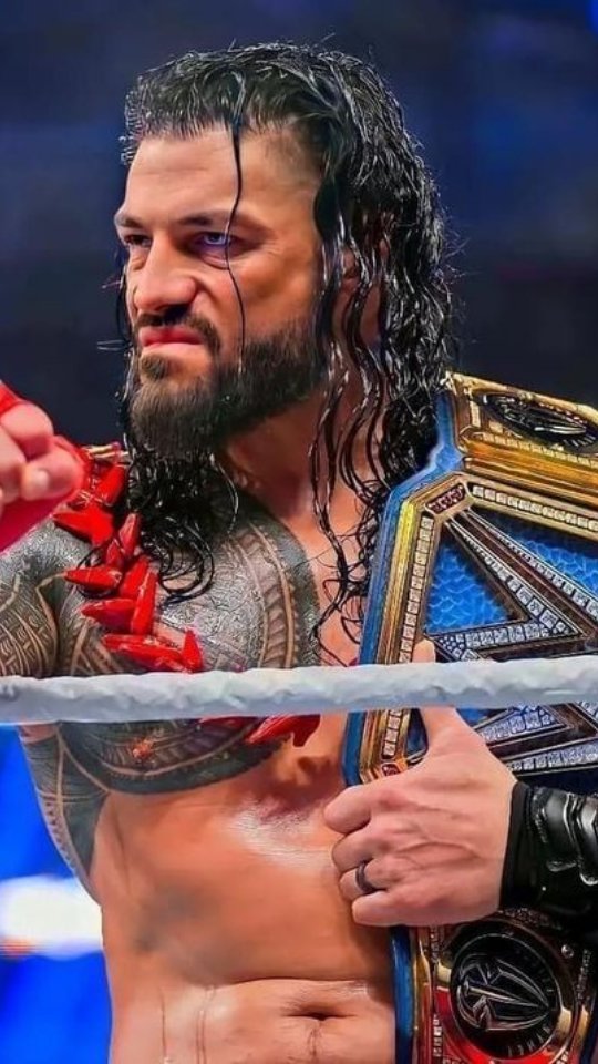 Roman Reigns holding his championsh...