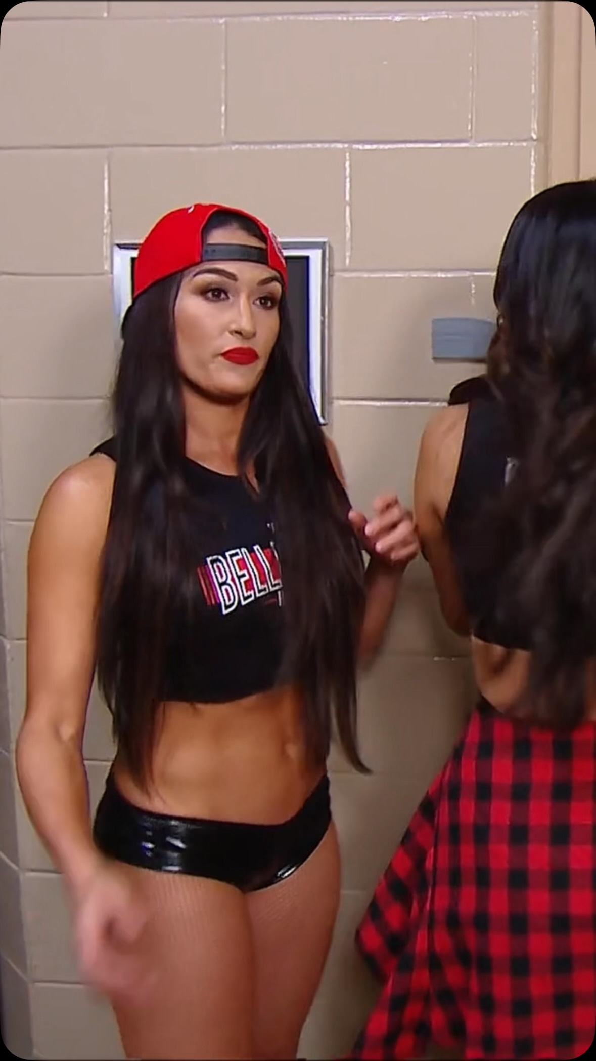 Nikki Bella in a red cap and crop t...